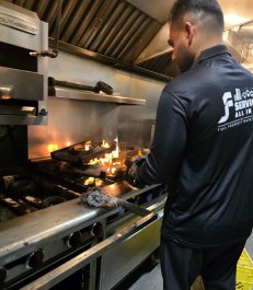 Commercial kitchen cleaning technician maintaining restaurant cooking equipment